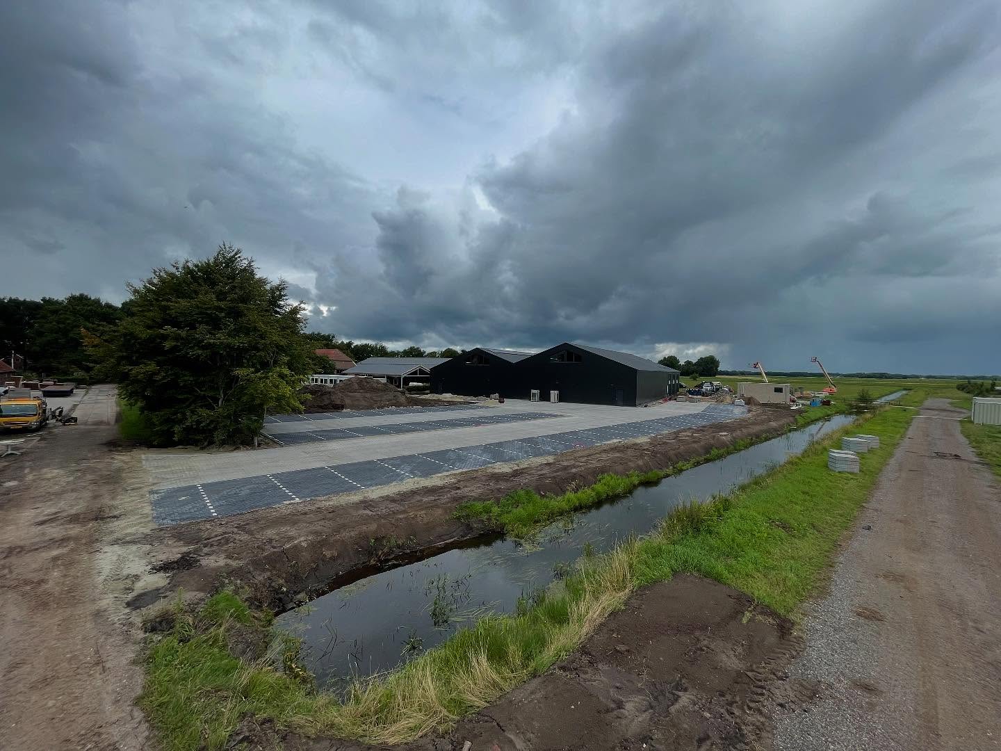 Groot machinaal gelegd bestratingsvlak bij een bedrijfsloods