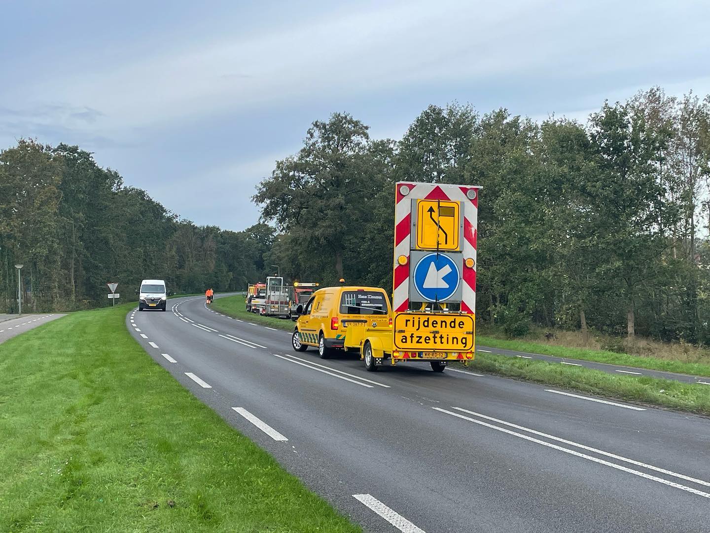 Bedrijfsbus met wegafzetting tijdens een klus langs de weg