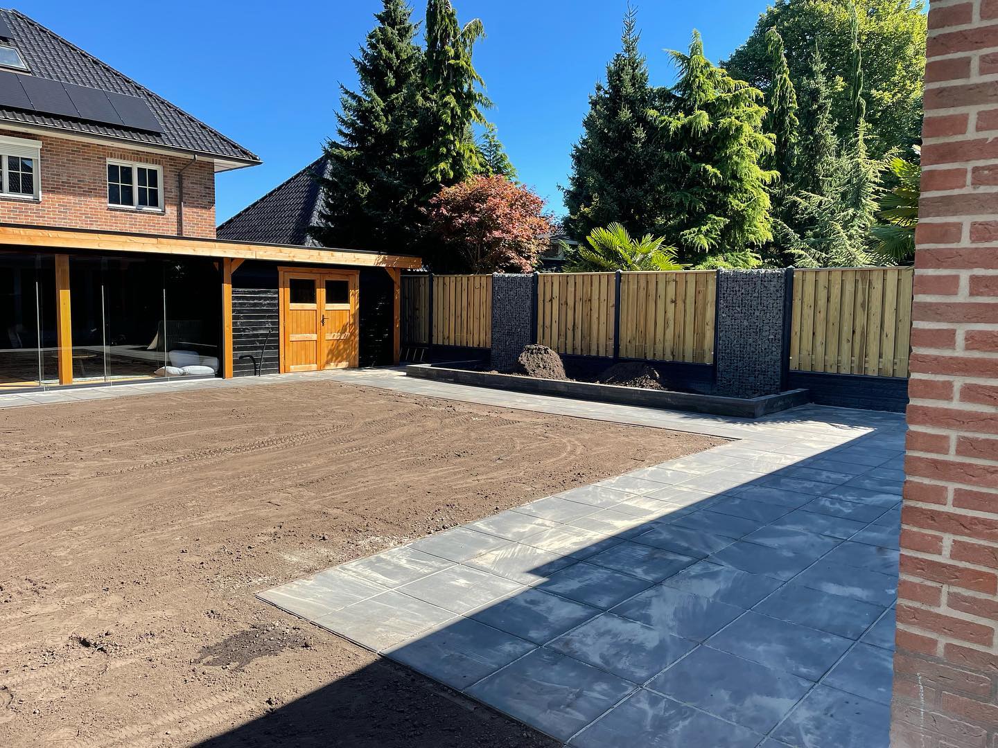 Afgeronde tuinbestrating met schutting
